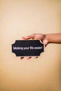 pexels-photo-7563656-7563656 Close-up of a hand holding a sign that reads 'Making your life easier.' Perfect for motivational content.